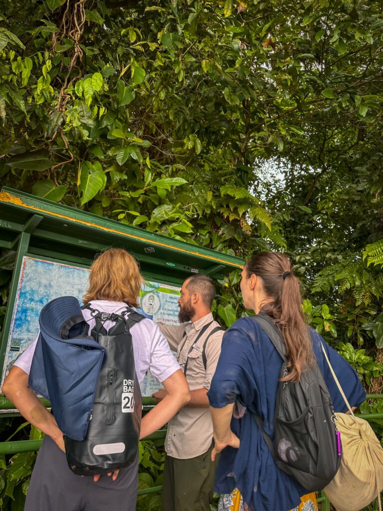 Boa explaining a map of Tortuguero National Park to guests, surrounded by lush greenery.