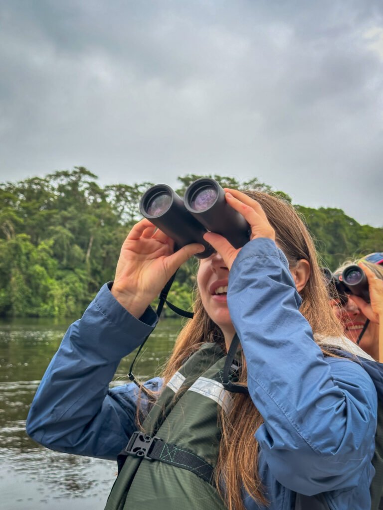 Tourists on a Guided Canoe Tour in Tortuguero National Park Using Binoculars to Spot Wildlife